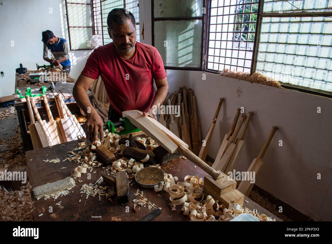 A worker uses hand planes to shape cricket bats at the Stanford cricket