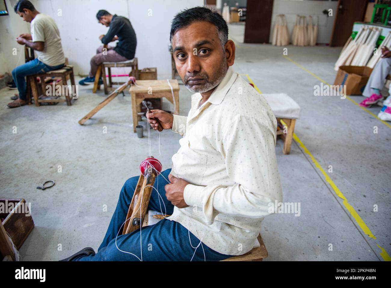 Meerut, India. 08th Apr, 2023. An employee stitches the leather seam