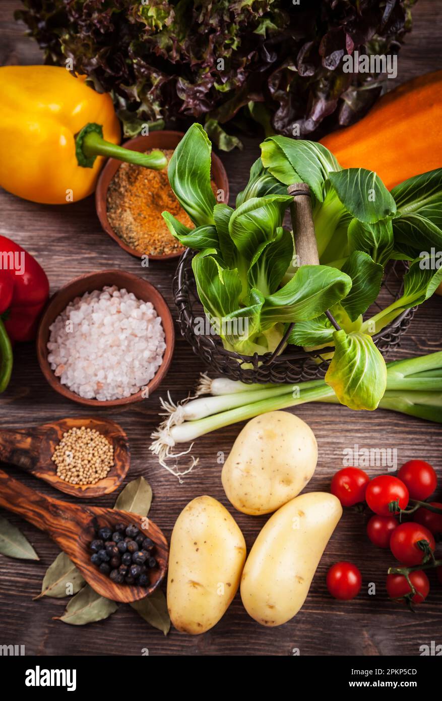 Raw vegetables with spices on wooden table Stock Photo