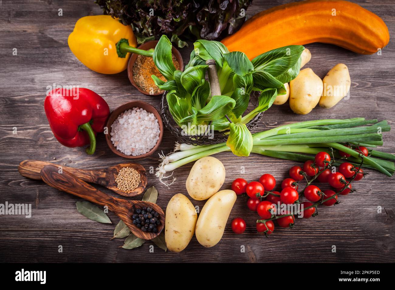 Raw vegetables with spices on wooden table Stock Photo