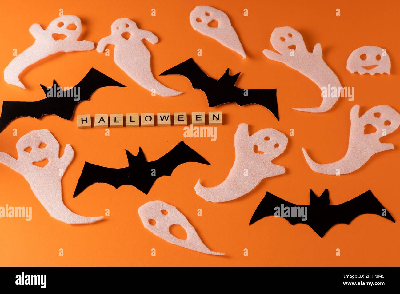 White ghosts and bat craft for Halloween party. Wrapping paper ghost on  orange background top view. Cartoon creepy Whisper. DIY hand made. Set boo  characters. Word wooden letter phrase Stock Photo -