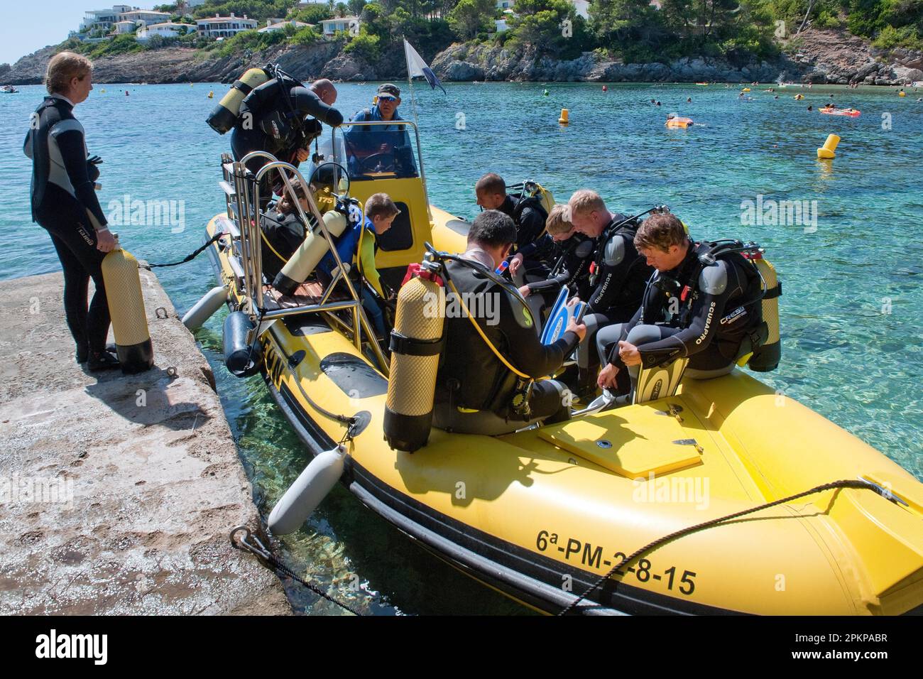 Diver in dinghy at pier, jetty, scuba tank, diving excursion, Font de