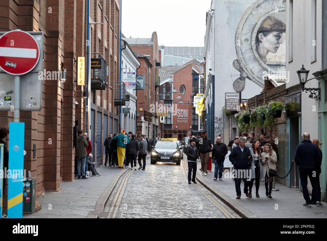 taxis driving through busy hill street on saturday evening cathedral quarter Belfast City Centre, Northern Ireland, UK Stock Photo