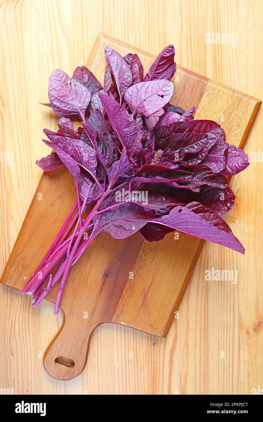 Top View of Fresh Organic Red Spinach or Amaranthus Dubius on Wooden Chopping Board Stock Photo