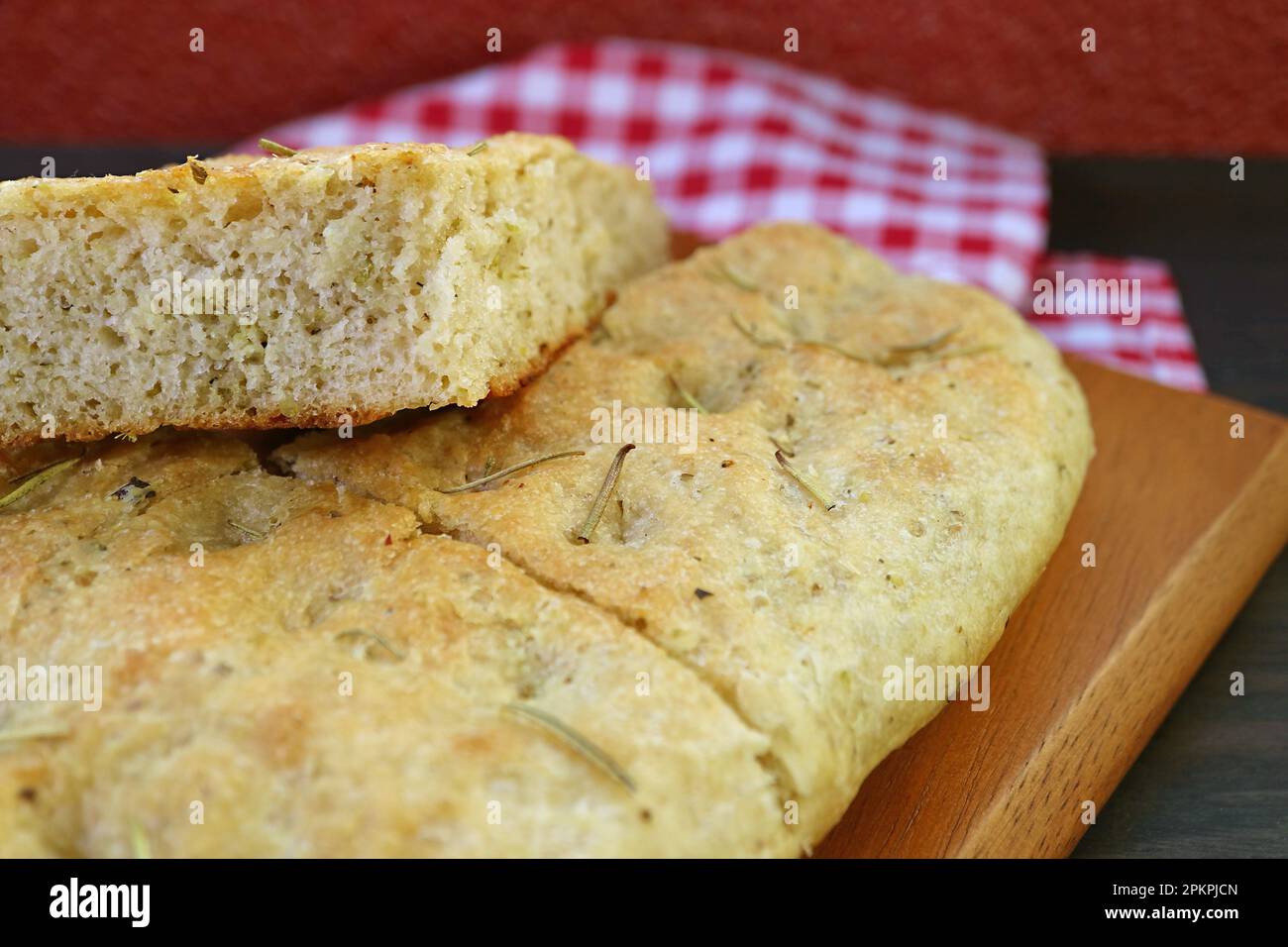 Closeup the Texture of Aromatic Rosemary Focaccia Bread Slices on Wooden Breadboard Stock Photo