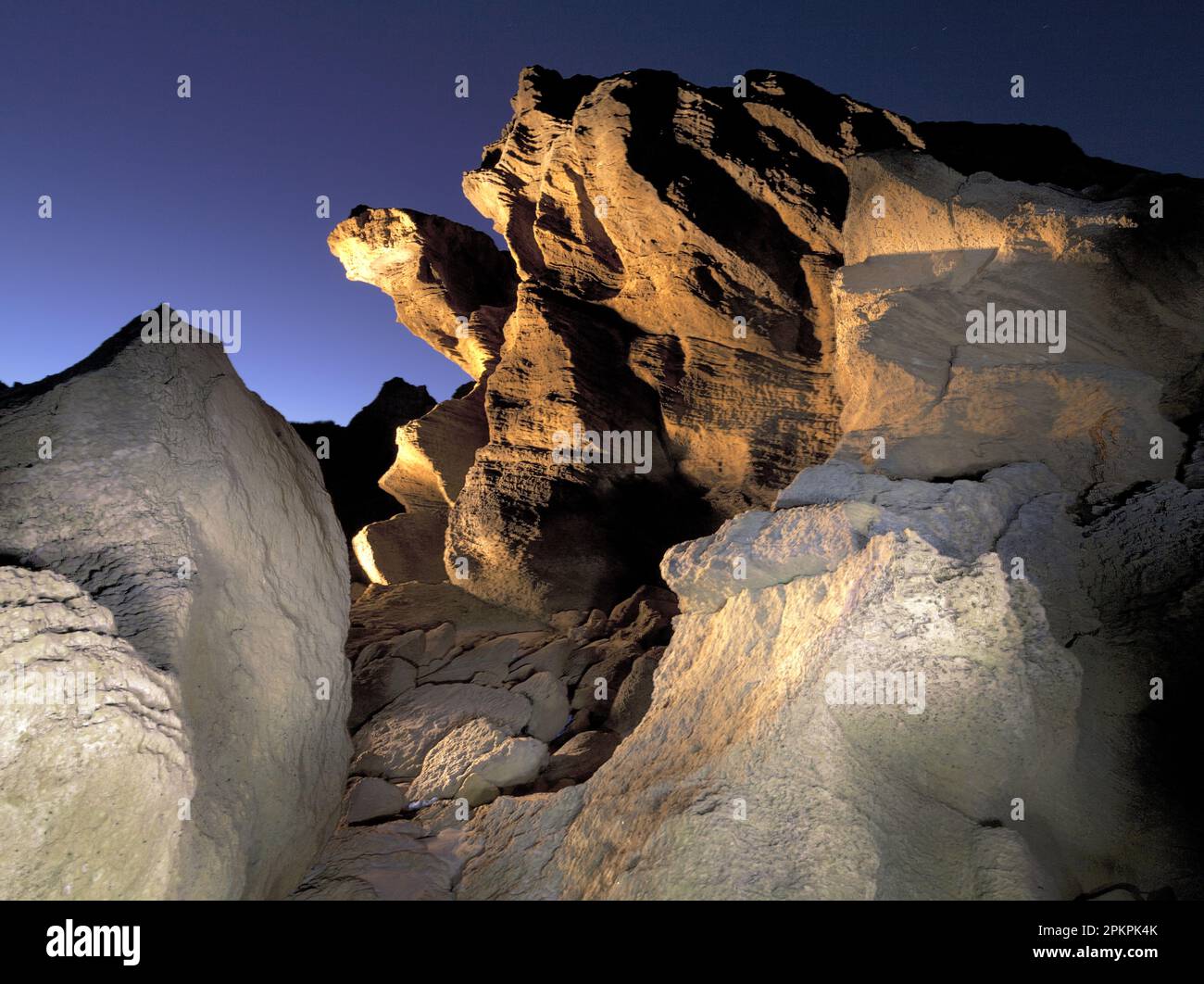 The strange shapes of the coastal rocks, along the beaches between Stilbaai and Gouritzmond, are painted by the beam of a powerful 1 million Candela h Stock Photo