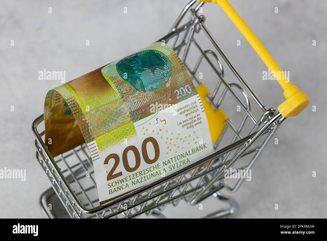 Financial concept, Inflation level in Switzerland, prices in stores, Empty shopping cart and 200 Swiss francs, close up Stock Photo