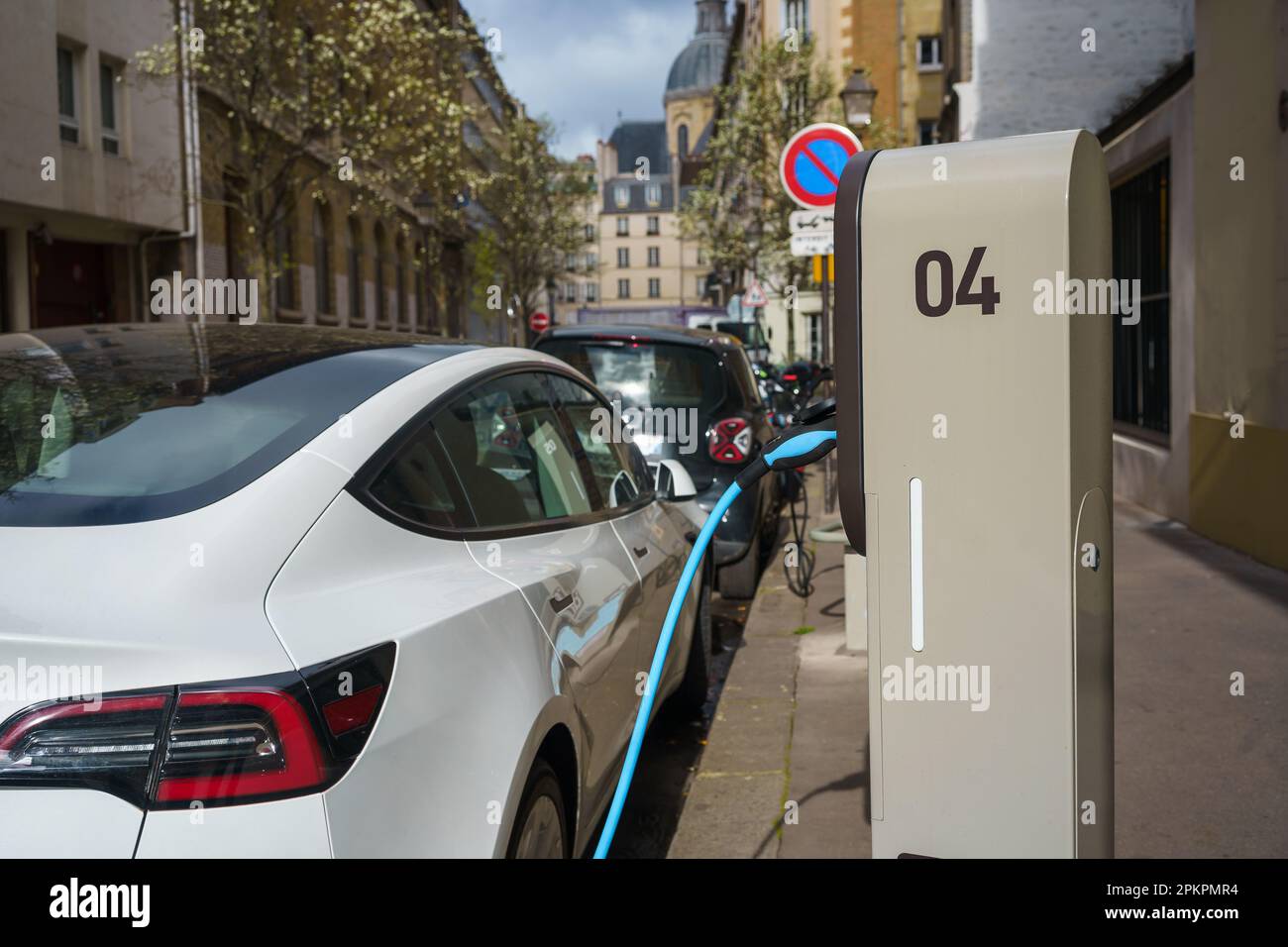 Electric car on EV charging station in the street of Paris, France