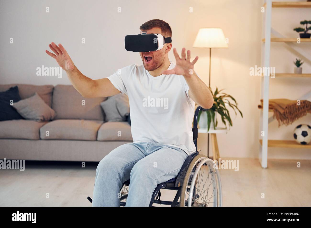 In VR glasses. Disabled man in wheelchair is at home Stock Photo - Alamy