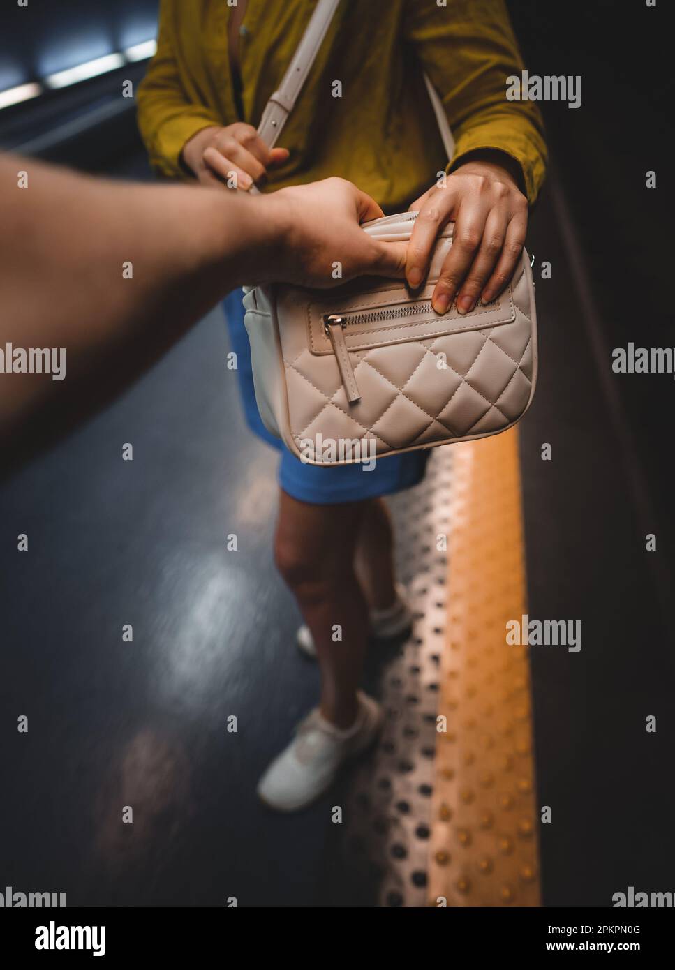 Thief steals a bag from a woman in the subway Stock Photo - Alamy