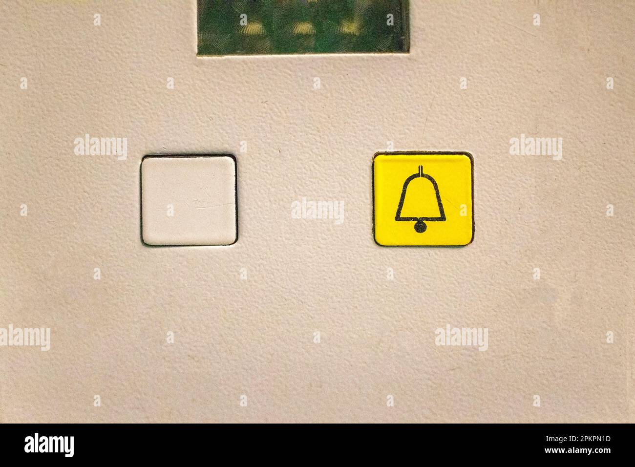 Two elevator buttons an empty and a yellow emergency button to rescue