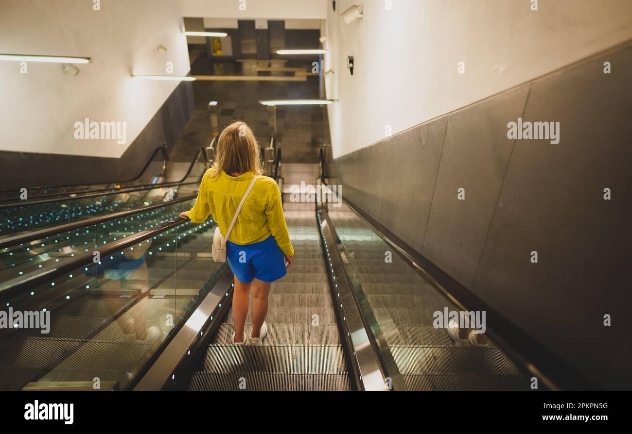 Woman using the escalator in the subway. Stock Photo