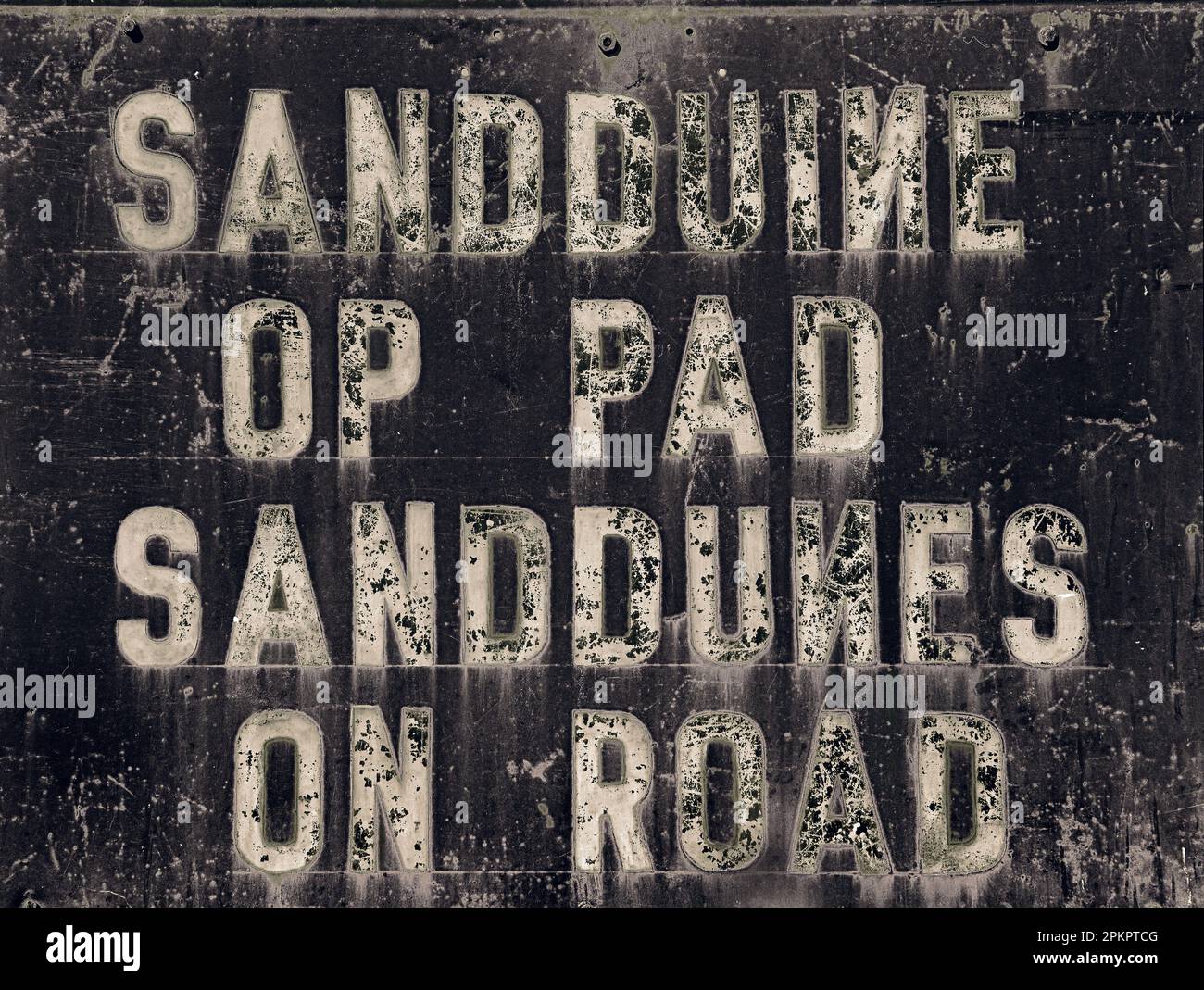 An old road sign warns of the possibility of sanddunes on the road ...