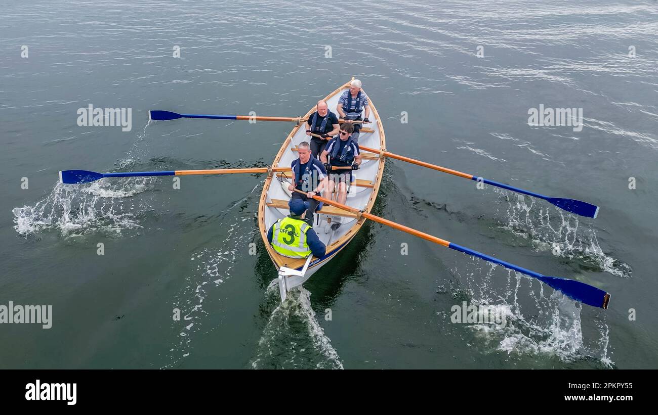 Rowers on a traditional wooden skiff rowing boat take part in a race