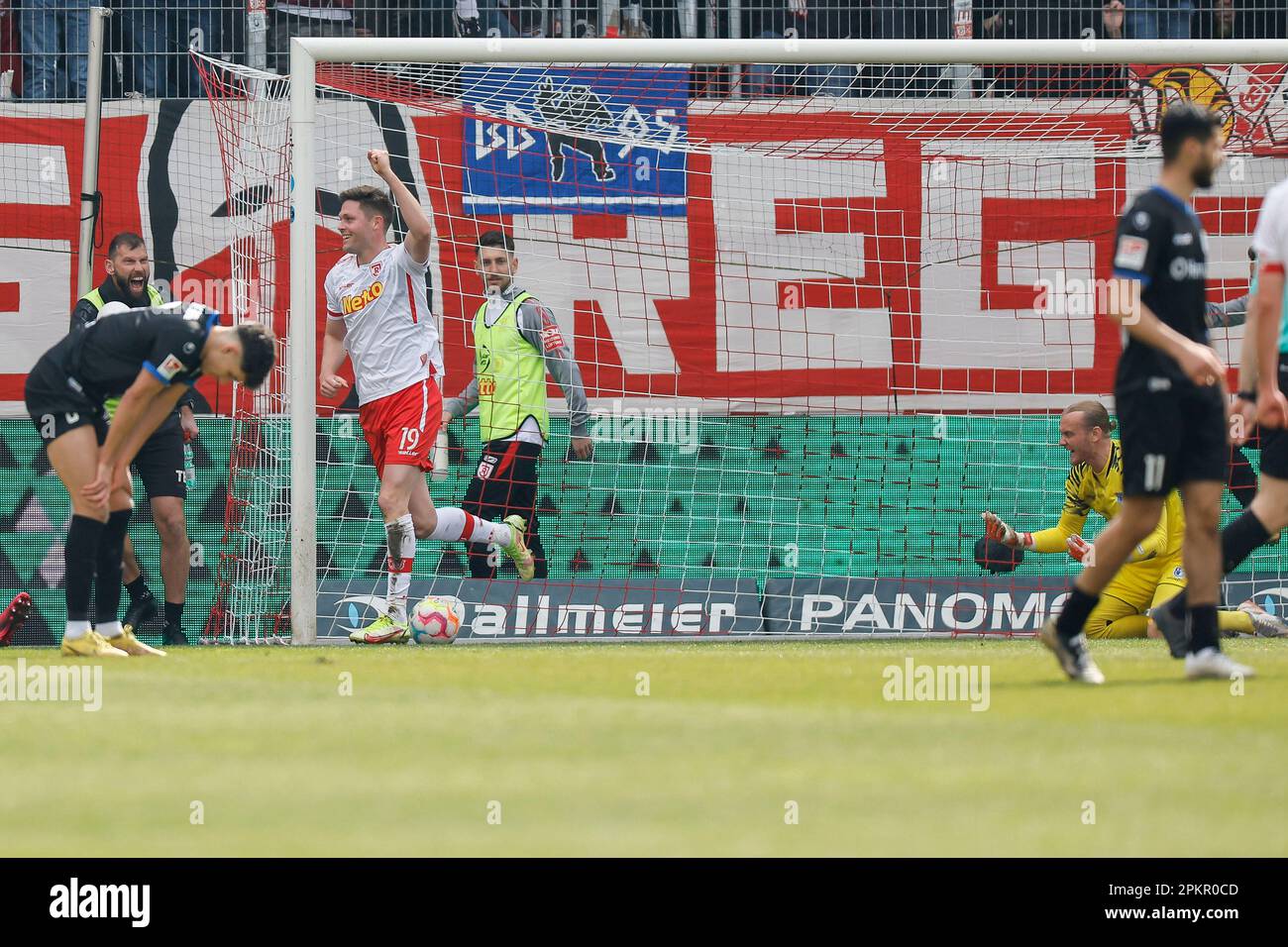 Regensburg, Germany. 09th Apr, 2023. Soccer: 2nd Bundesliga, Jahn Regensburg - 1. FC Magdeburg, Matchday 27, Jahnstadion Regensburg. Andreas Albers (2nd from left) from Regensburg celebrates his goal to make it 1:1, Magdeburg goalkeeper Dominik Reimann (r) is annoyed. Credit: Daniel Löb/dpa - IMPORTANT NOTE: In accordance with the requirements of the DFL Deutsche Fußball Liga and the DFB Deutscher Fußball-Bund, it is prohibited to use or have used photographs taken in the stadium and/or of the match in the form of sequence pictures and/or video-like photo series./dpa/Alamy Live News Stock Photo