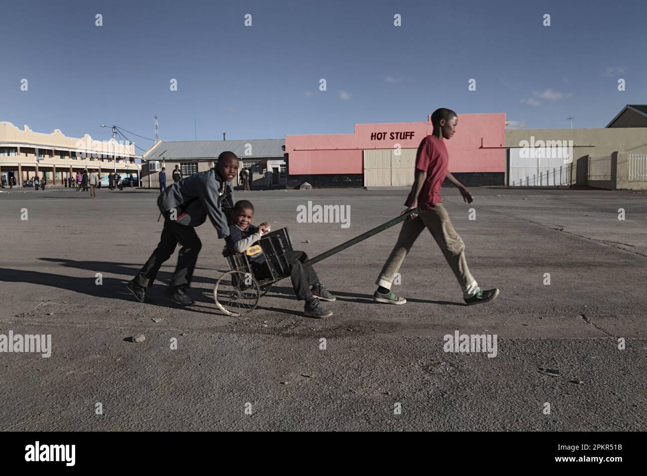 Three youths move across an empty parking area in the Northern Cape