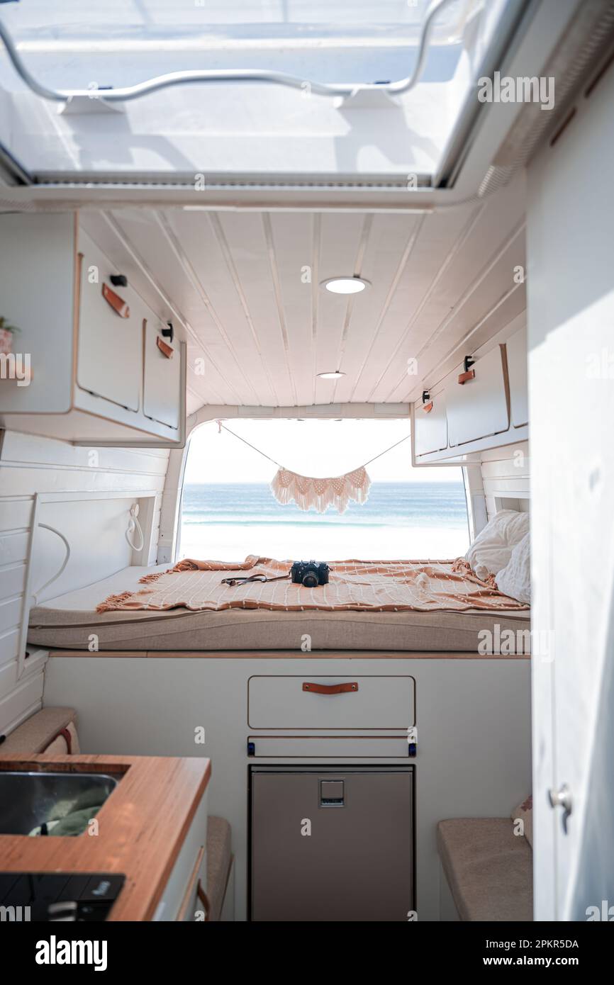 Stunning view of the interior of a van parked on a beach with the ocean in the distance. Life on the road concept, nomadic lifestyle. Fuerteventura. Stock Photo