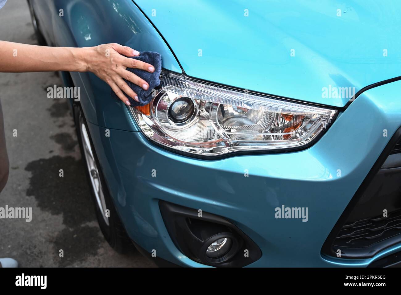 Cleaning car using active foam. Woman washing his car on self car
