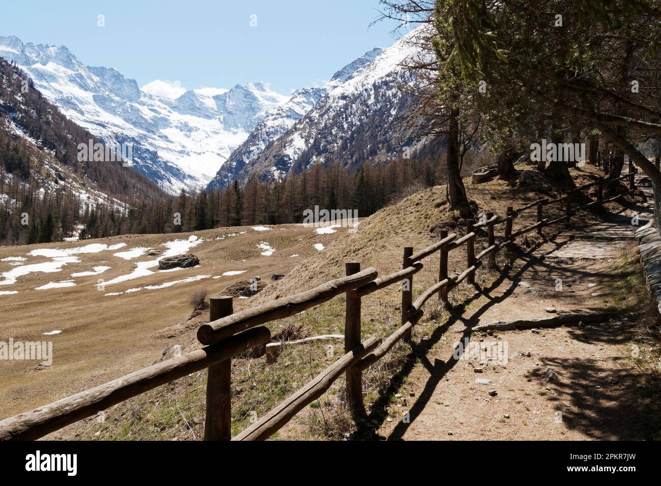 Walking path trail with snow covered mountains behind in Valnontey, Gran Paradiso National Park, Aosta Valley, Italy Stock Photo