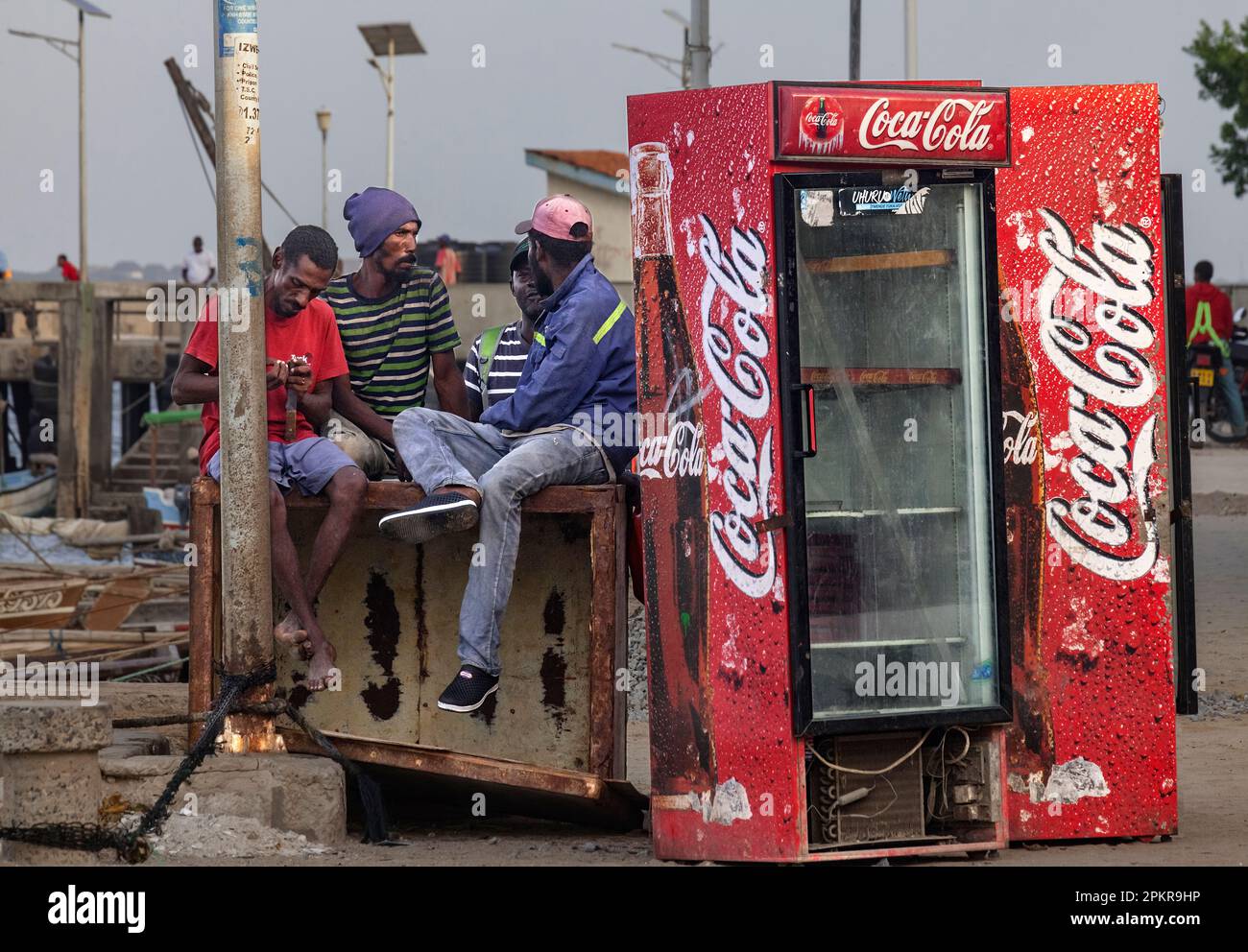 An discarded Coco Cola fridge stands on the harbour in Lamu town. Stock Photo