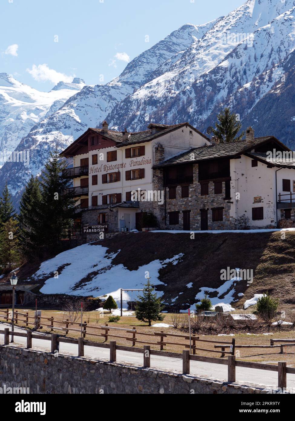 Hotel surrounding by snow covered mountains in Valnontey, Gran Paradiso National Park, Aosta Valley, Italy Stock Photo