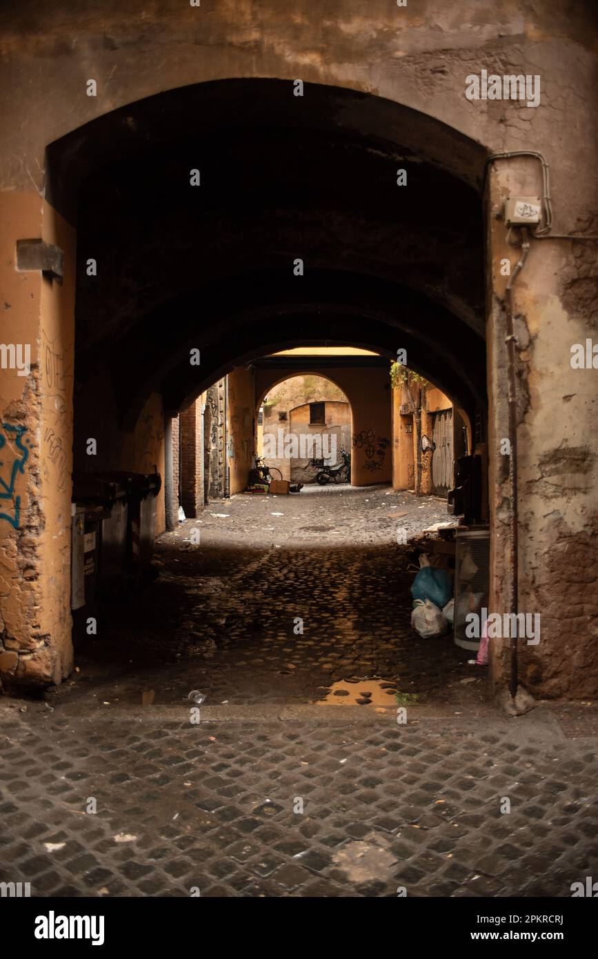 Alleyway in Rome with arches and abandoned thrash Stock Photo