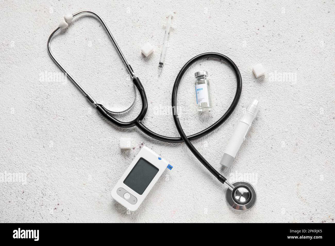 with insulin, lancet pen, stethoscope and sugar on white