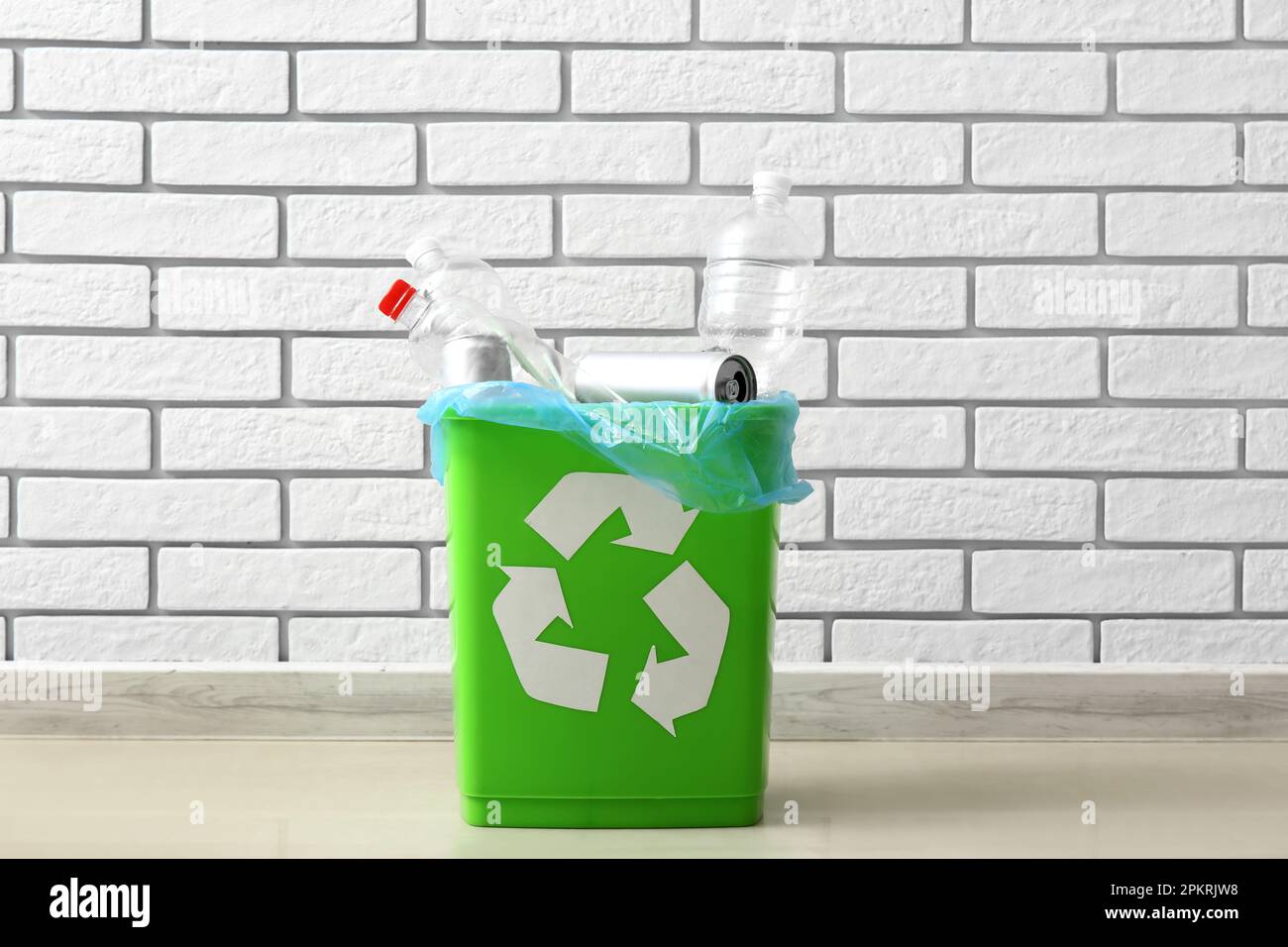 Recycling bin with garbage near white brick wall Stock Photo Alamy