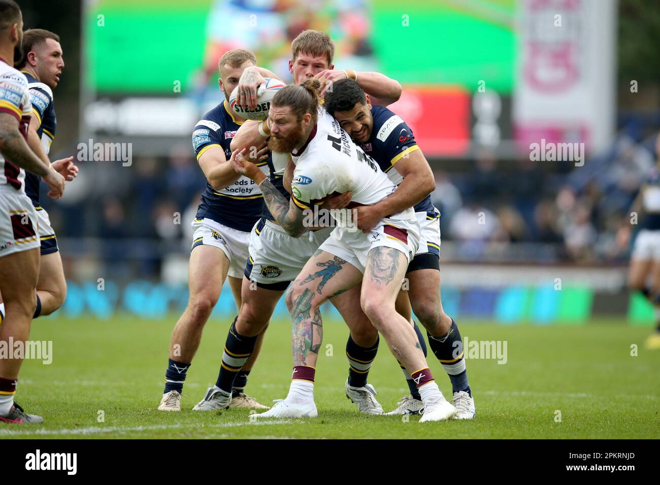 Huddersfield Giants’ James McQueen is tackled by Leeds Rhinos’ Sam ...