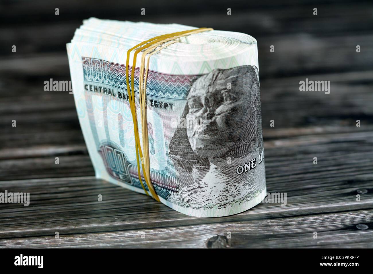 Folded 100 EGP LE one hundred Egyptian pounds cash money bills rolled with  rubber band, Egypt money bundle pounds features Sultan Hassan mosque and t  Stock Photo - Alamy