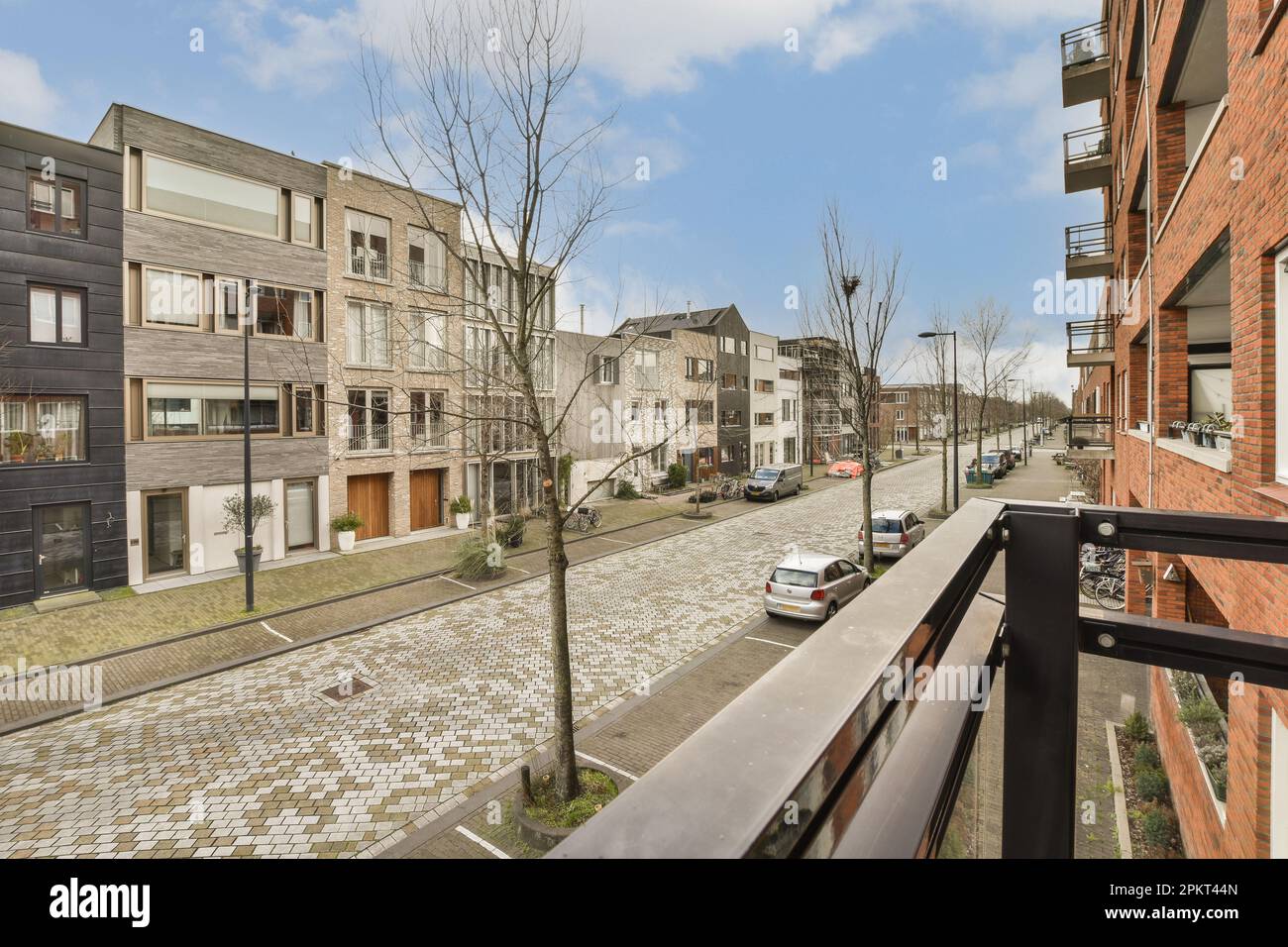an outside area with cars parked on the street and houses in the ...