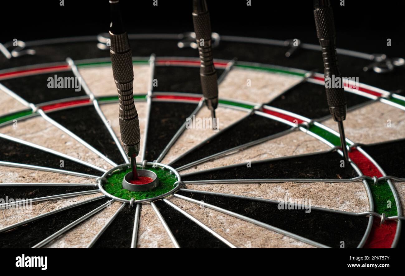 Three darts hit the dartboard. Lucky - one of the darts hits the bull's  eye. The concept of winning and luck. Close-up, angled view Stock Photo -  Alamy