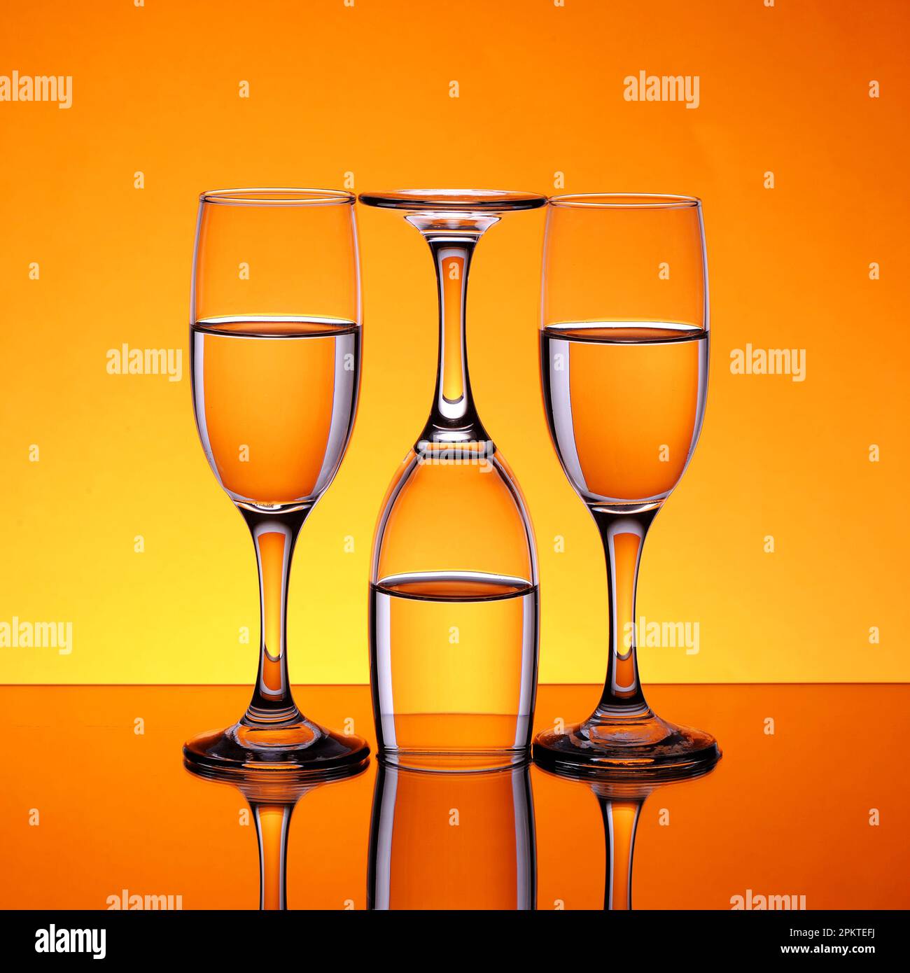 Glass goblets with water in them, two straight and the other inverted