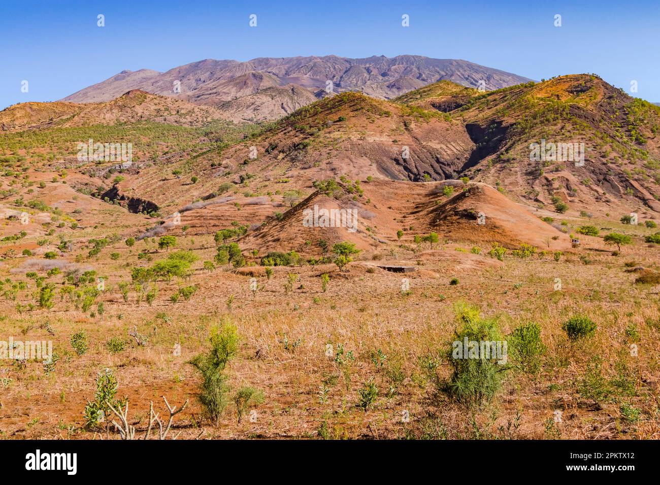 A picturesque mountain slope formed by volcanism overgrown with grass and bushes, Fogo Island, Cape Verde Islands Stock Photo