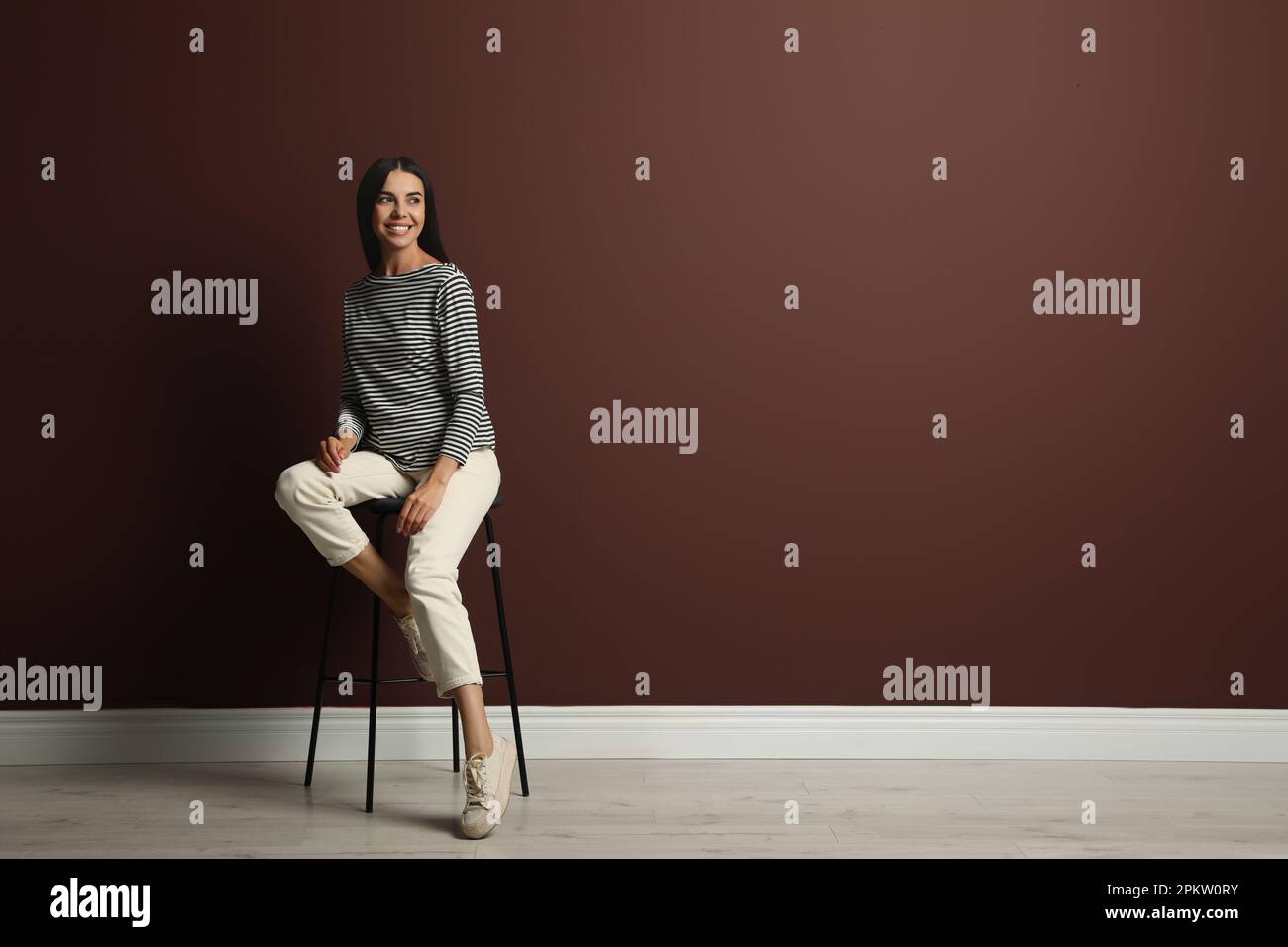 Young woman sitting on stool hi-res stock photography and images - Alamy