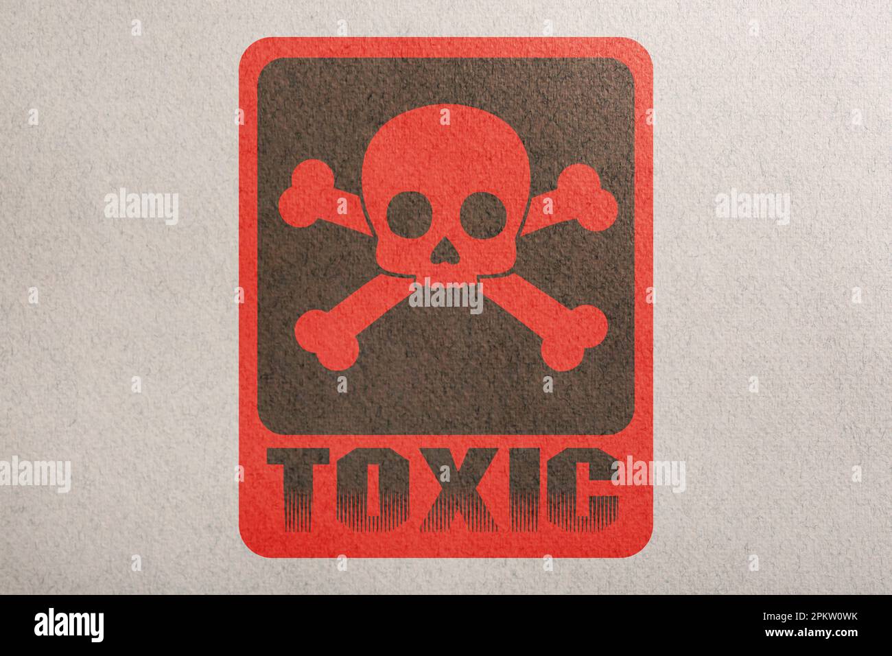 Hazard warning sign (skullandcrossbones symbol and word TOXIC) on paper, top view Stock Photo