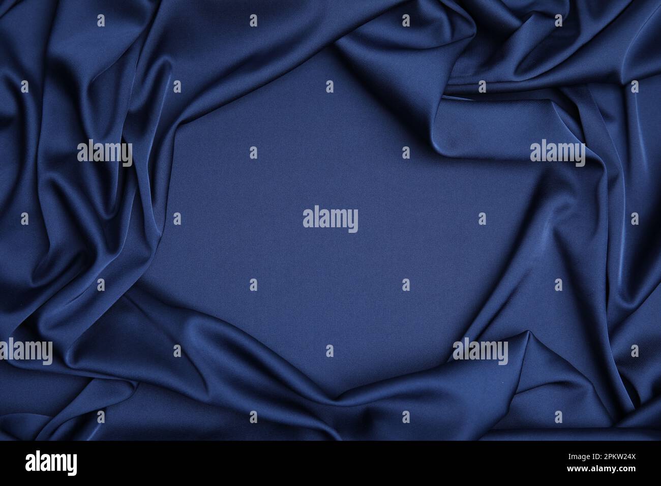 Crumpled dark blue silk fabric as background, top view. Space for text ...