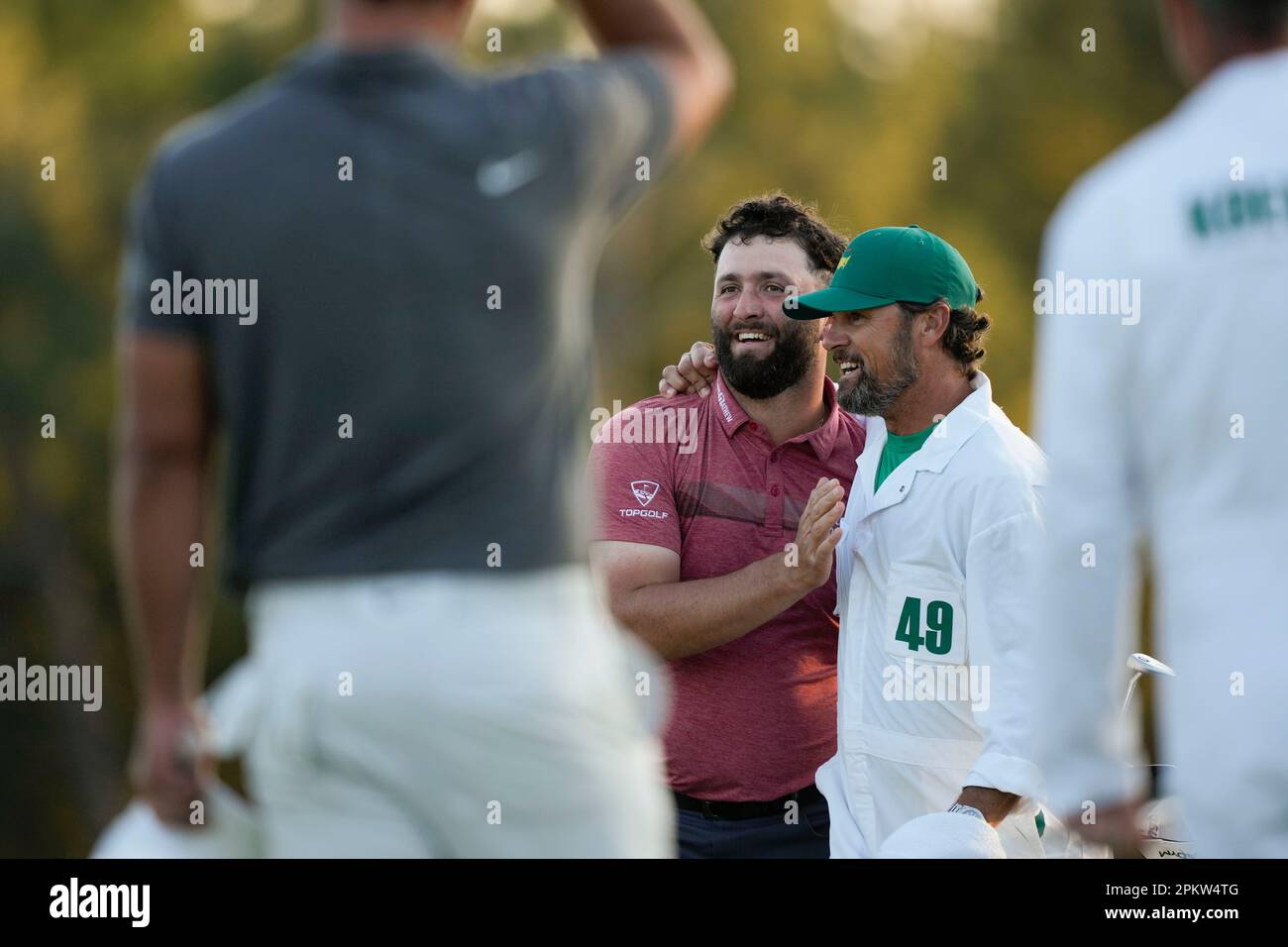 Jon Rahm, of Spain, embraces his caddie Adam Hayes holding the trophy