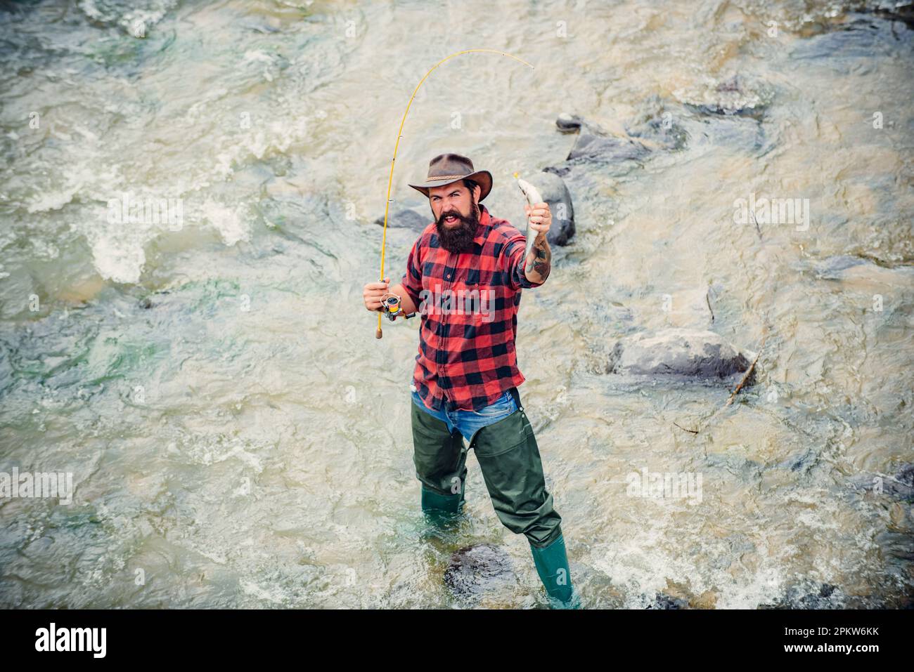 Exited Fish Fisherman caught a fish. Excited amazed fisher man in water catching ...