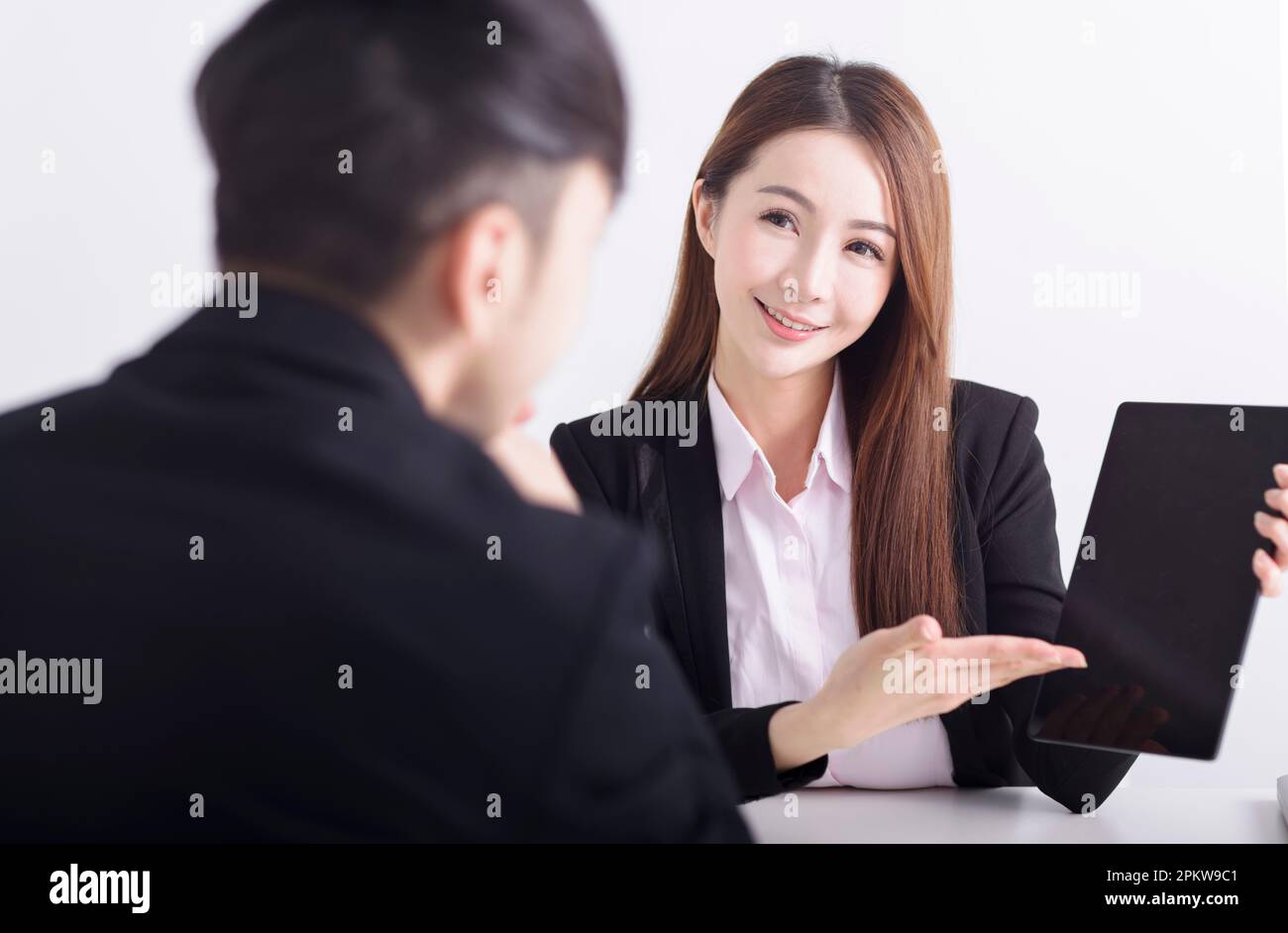 Business women are introducing or consulting businesses to male employees with mobile tablet Stock Photo