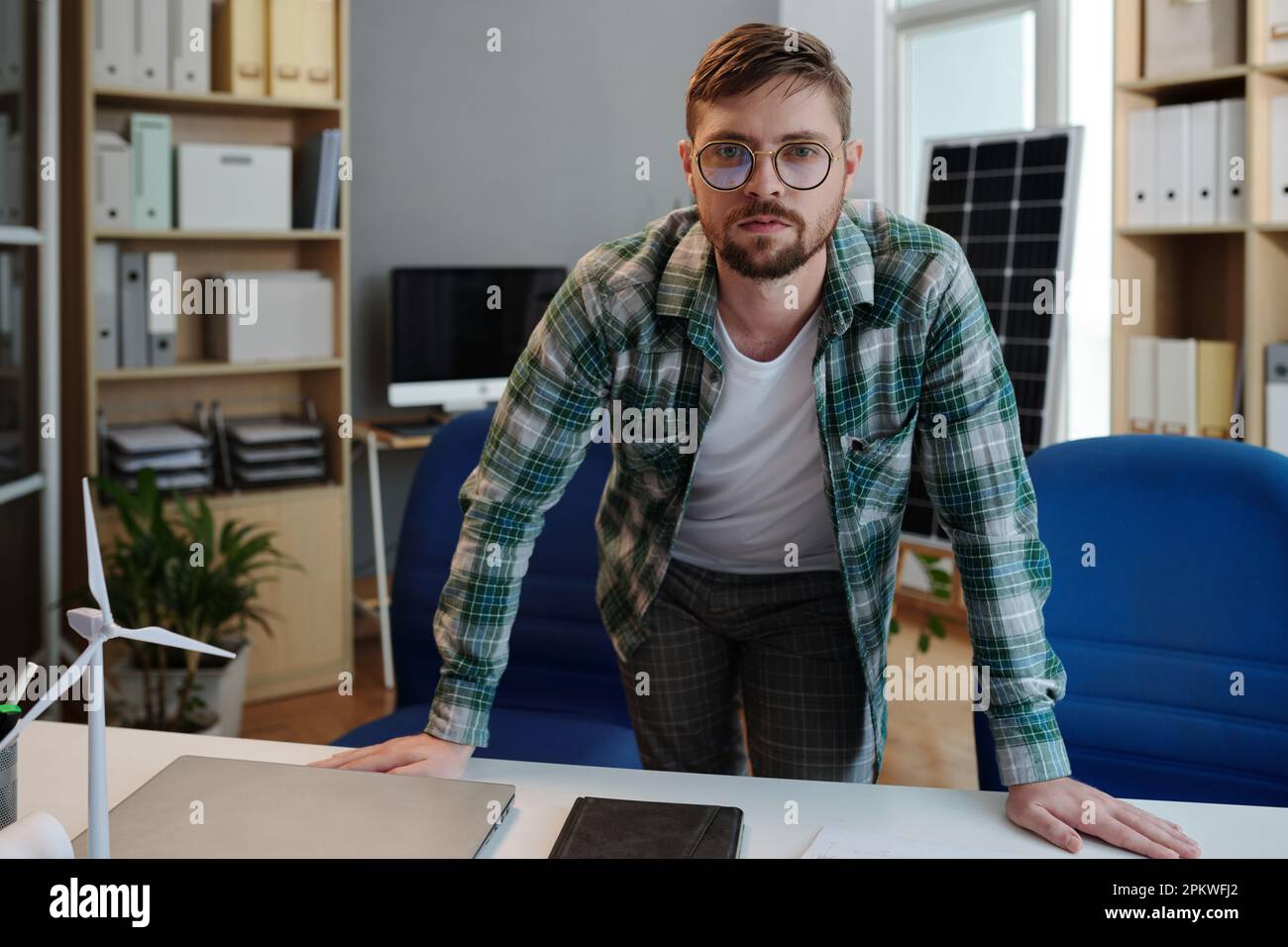 Portrait of sustainable energy engineer standing at his desk Stock Photo