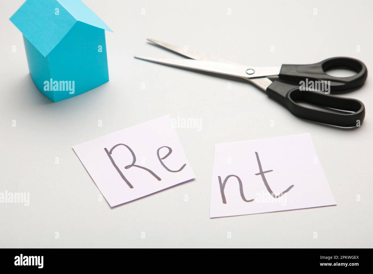 The word 'Rent' written on paper and cut in half with a pair of