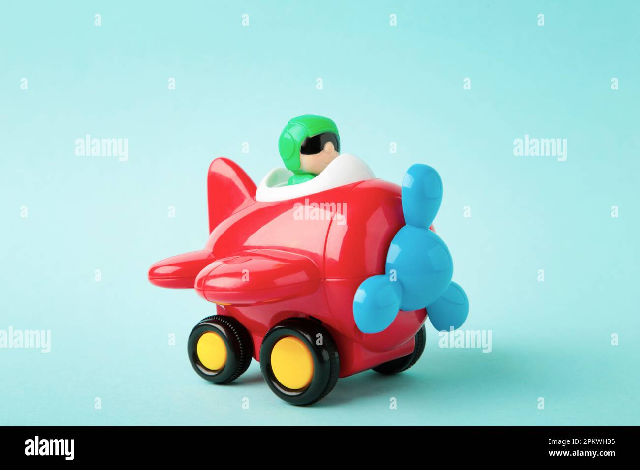 Plastic toy plane on blue background. Top view Stock Photo