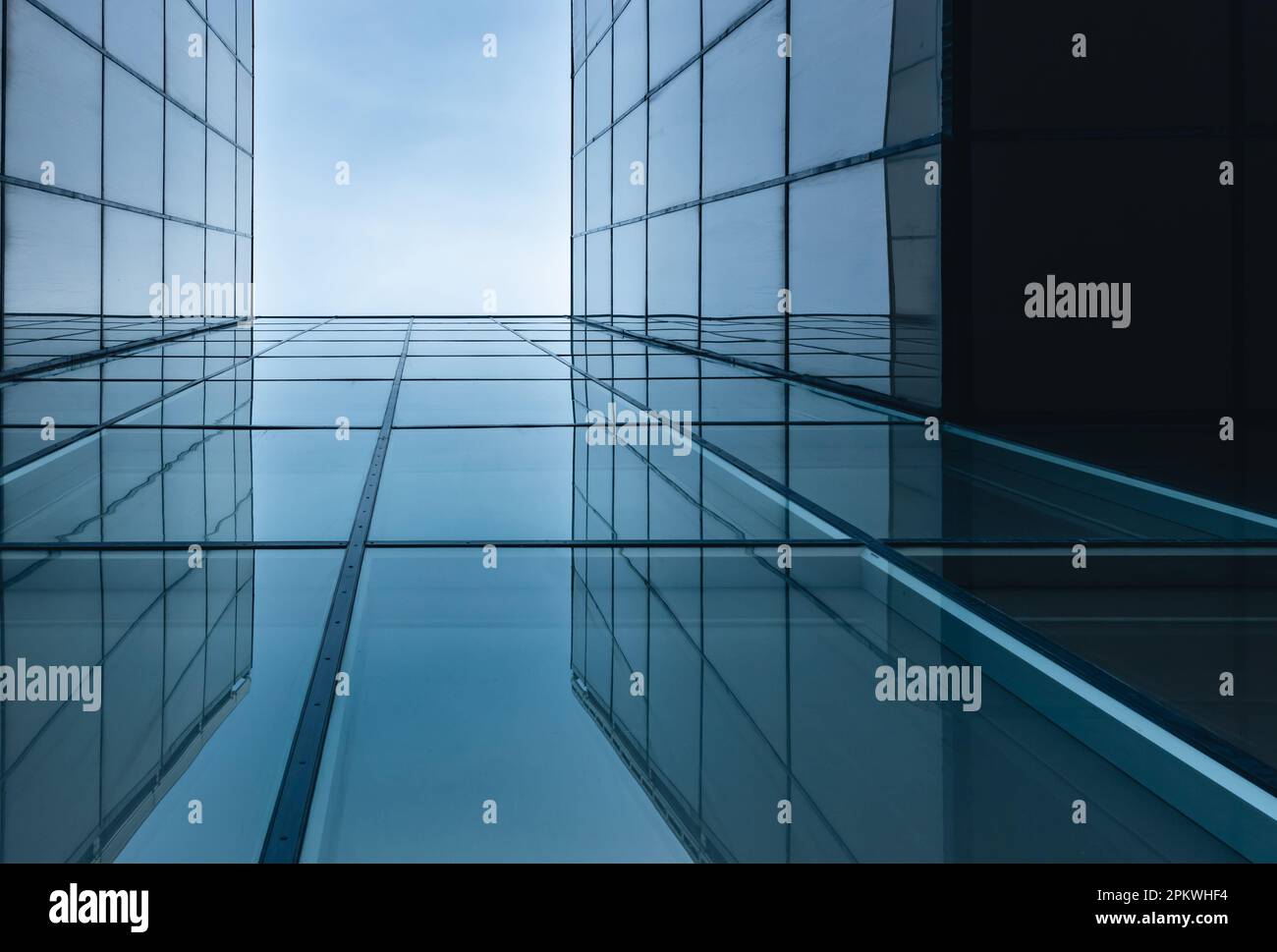 The blue sky is reflected in the windows of a modern office building ...