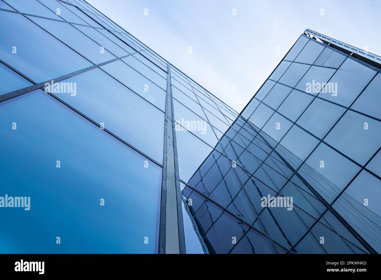 The blue sky is reflected in the windows of a modern office building ...
