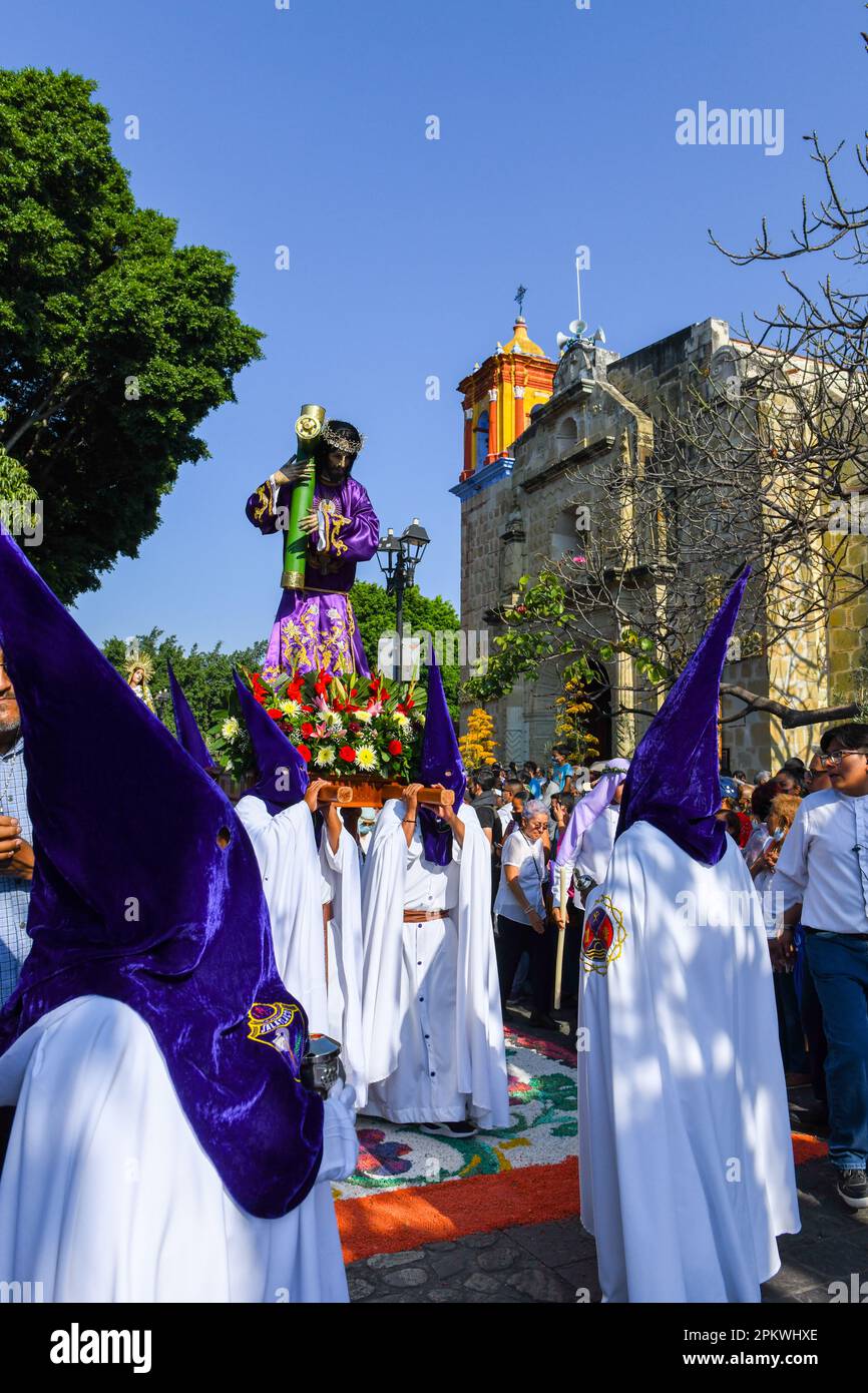 Mexican hooded devotees carry the religious palanquin during during the Good Friday procession, on the Holy week, Oaxaca de Juárez , Mexico Stock Photo