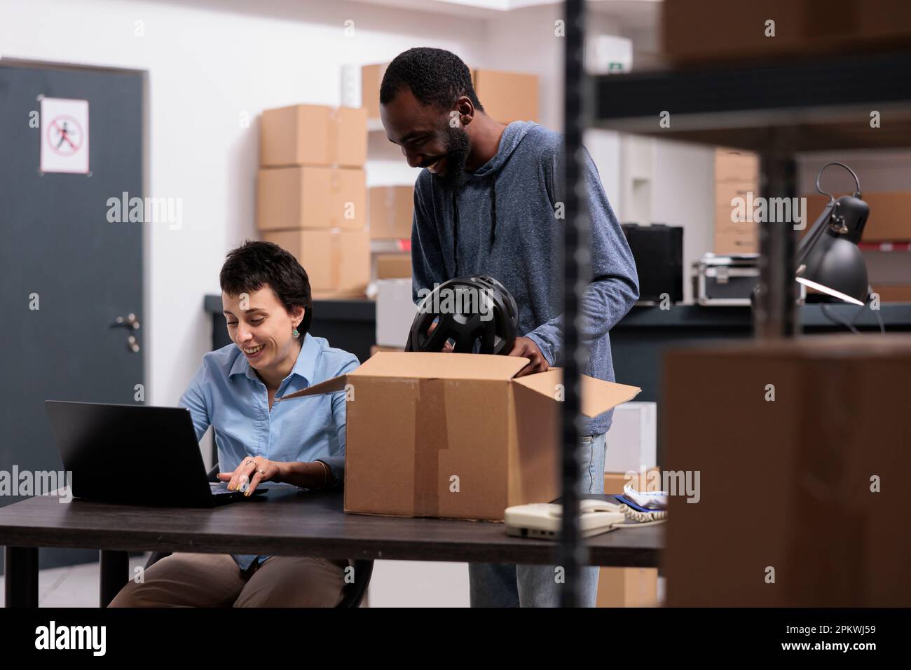 African american worker putting client helmet order in carton box ...
