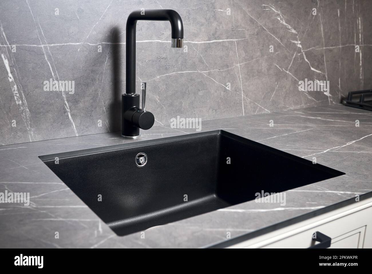 Kitchen sink area with black square matte sink tap in contemporary style. Matte black and