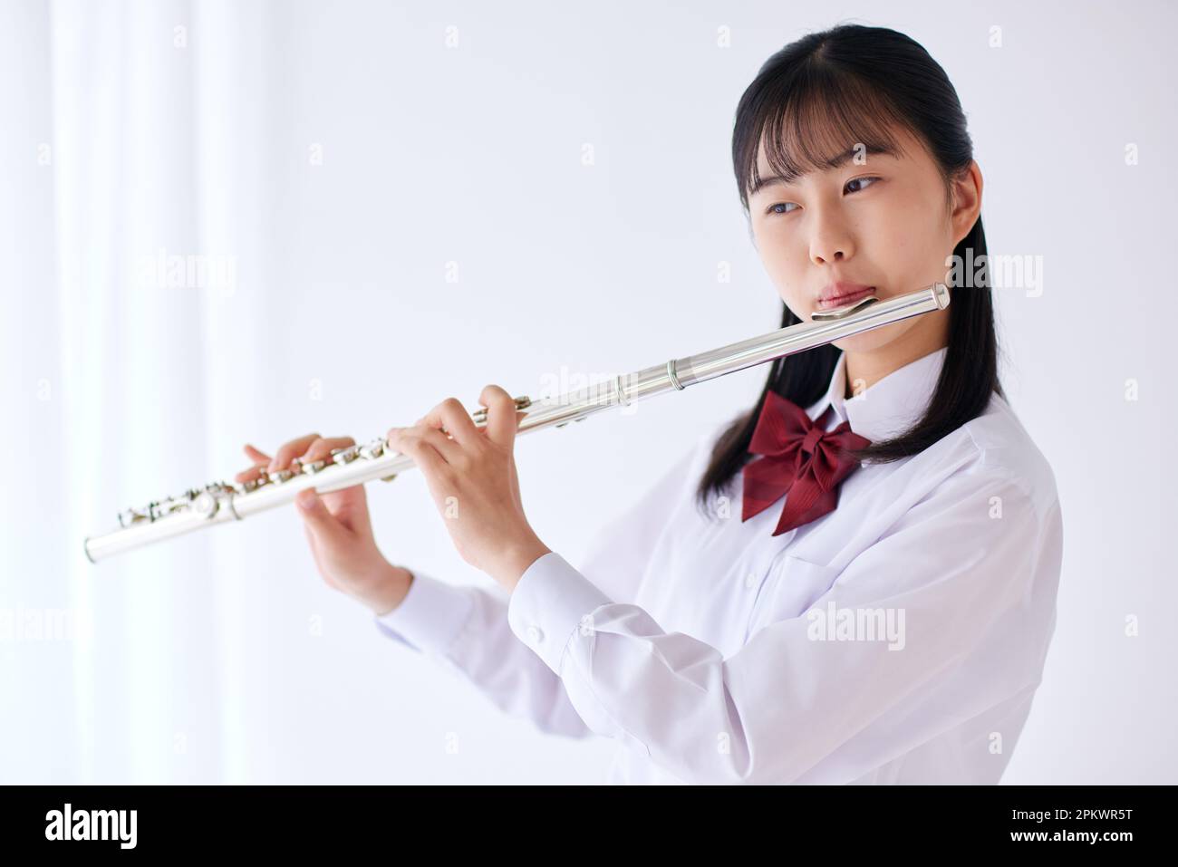 Japanese high school student wearing uniform practicing music Stock