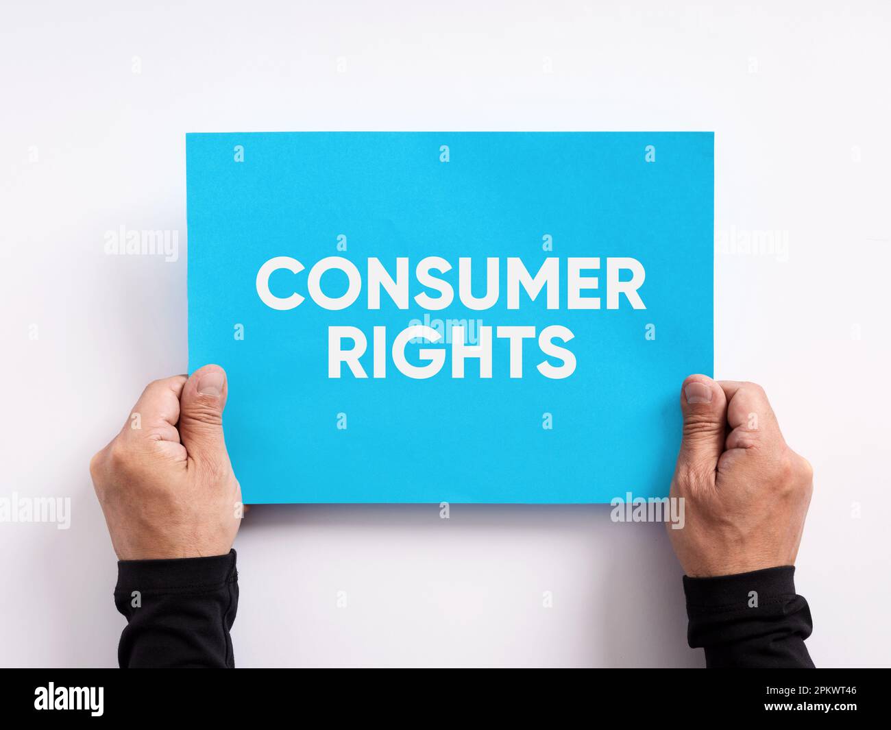 Male hand holding a blue paper with the word consumer rights. Stock Photo